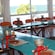 A room featuring long tables with chocolate workshop tools, chairs and windows overlooking the ocean